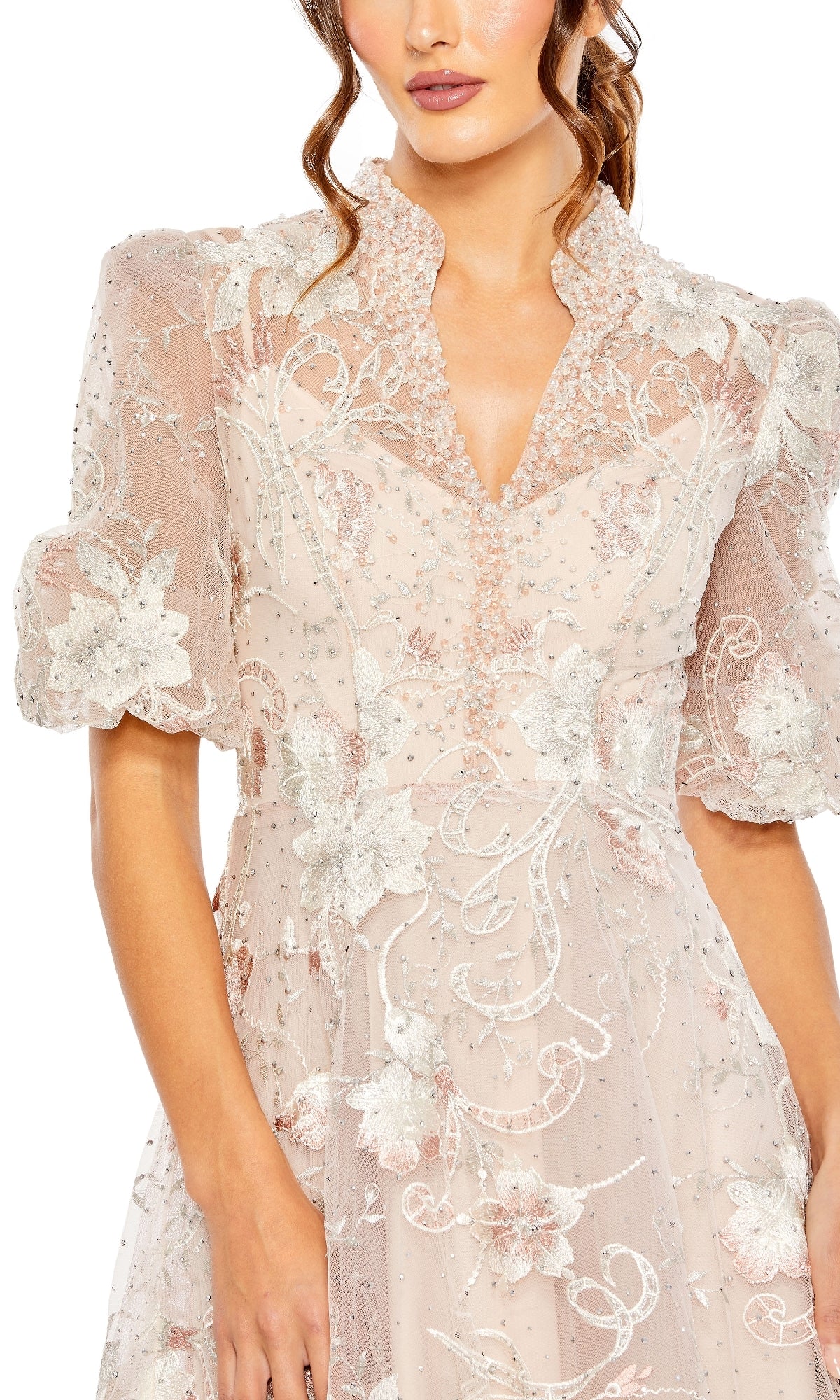 A woman models the Mac Duggal 20452 Long Formal Dress, featuring a sheer, floral embroidered bodice with puffed short sleeves, a V-neckline, and detailed beading. Only her upper body is shown in this elegant design.